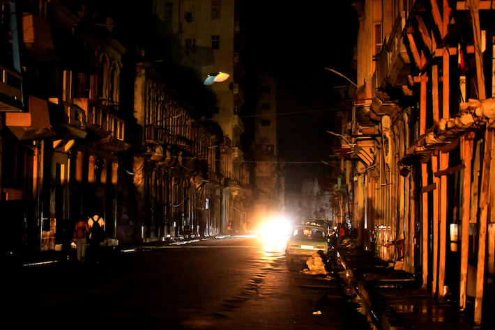 Người dân đi bộ trên đường phố vào ban đêm khi Cuba bị mất điện toàn đảo. Ảnh: Reuters.