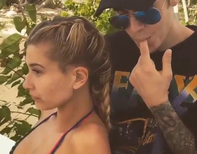Nam ca sĩ trẻ tuổi liếm ngón tay trỏ rồi nhẹ nhàng đặt vào tai Hailey Baldwin.