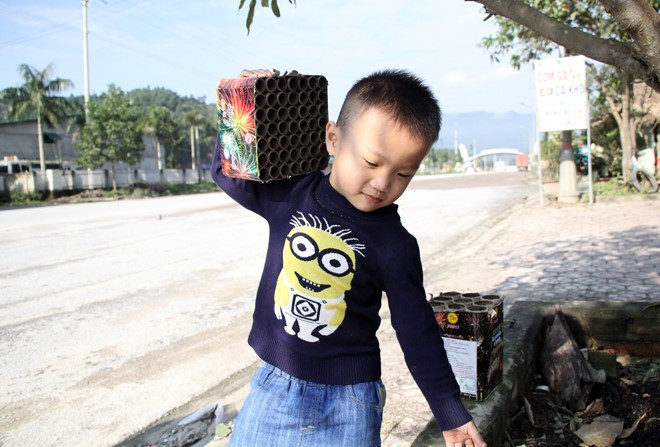 Trần Bảo Lâm (hơn 4 tuổi) ở cổng B, Khu kinh tế Cửa khẩu Cầu Treo nhặt xác pháo hoa về chơi.