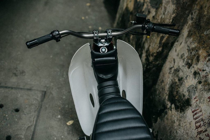 Việc nới rộng phuộc trước khiến bộ yếm nguyên bản của Super Cub đã không còn lắp vừa. Để khắc phục, xưởng độ đã cắt đôi nửa trên của yếm và che lại bởi một bộ túi da may thủ công.