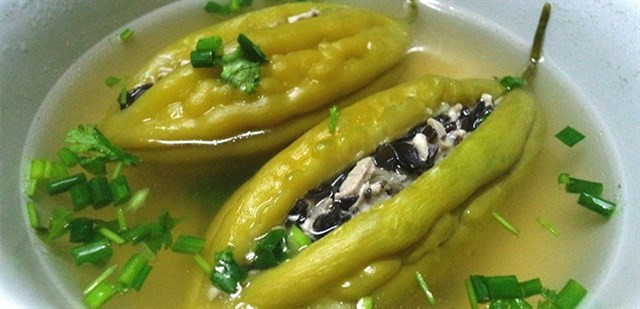 Bạn trần khổ qua trong nước sôi khoảng 2 phút rồi vớt ra ngâm vào nước lạnh. Khi khổ qua nguội, bạn vớt ra và nhồi hỗn hợp thịt xay vào bên trong ruột, dùng hành lá để buộc trái khổ qua lại. Ảnh: 2monngonmoingay.