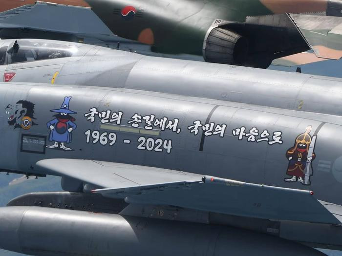 Một chiếc F-4E màu xám khác có khẩu hiệu chia tay và năm phục vụ của tiêm kích "Phantom" trong Lực lượng Không quân Hàn Quốc, với dòng chữ 1969-2024 nổi bật trên thân máy bay.