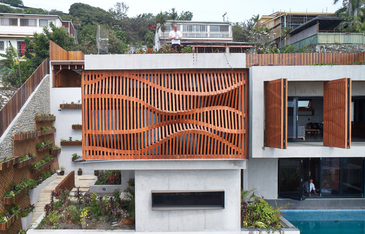 Brise Soleil House là một tòa nhà bê tông đúc sẵn, một phần của nó được bao bọc bằng gỗ uốn lượn nhấp nhô như sóng, vừa bảo đảm sự riêng tư vừa có tác dụng thông gió.