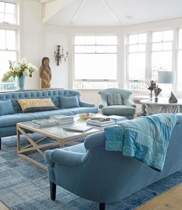 Bộ bàn ghế sofa màu xanh dương và thảm trải sàn nổi bật giữa phòng khách. Ảnh: Noithatductinh.