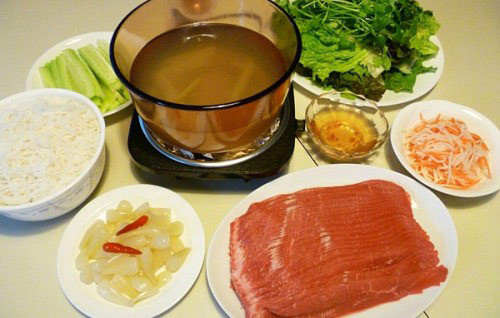 Lẩu bò nhúng dấm là món ăn kết hợp giữa lẩu và cuốn. Một suất bò nhúng dấm gồm có thịt bắp bò hoặc bò thăn, nước lẩu chua dịu vị dấm, thơm phức vị sả, cốt dừa. Bò sau khi chần trong nồi sẽ được cuốn với bánh đa, dứa, chuối xanh cắt chỉ cùng rau thơm, cải thảo, hành chần, bún…Ảnh: phununet