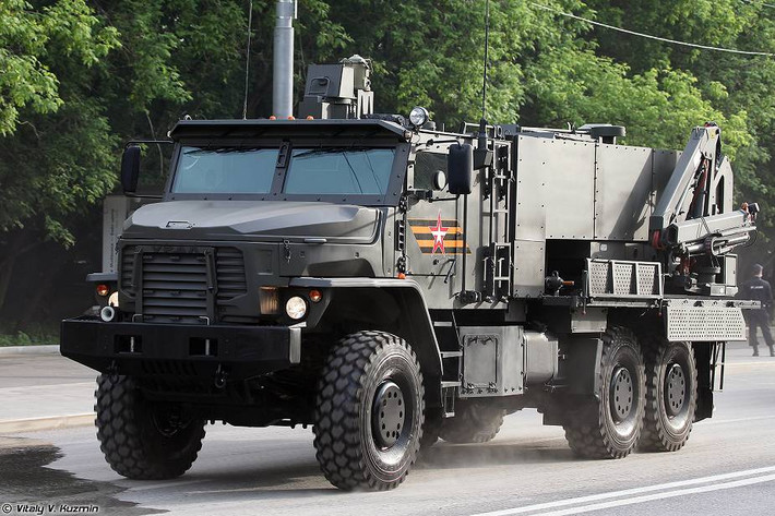 Nhằm khắc phục hạn chế của TOS-1A có tầm bắn khá ngắn ( tối đa 6.000m), TOS-2 sử dụng loại đạn mới có tầm bắn xa hơn đồng thời quá trình ngắm bắn, nạp phần tử cũng được thực hiện một cách tự động. Nhà sản xuất cũng cho biết, họ phải bàn giao những hệ thống TOS-2 đầu tiên cho quân đội Nga trong năm 2021 tới đây để có thể chiến đấu cũng như đưa sang Syria thử nghiệm. Ảnh: Hệ thống TOS-2 đang di chuyển trên đường.