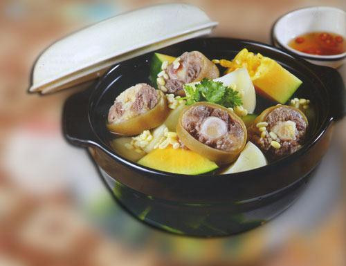 Món 4: Canh đuôi heo hầm đu đủ. Đuôi heo mua về cạo rửa sạch, chặt khúc 5 phân. Hành tím lột vỏ xắt mỏng. Đu đủ gọt vỏ thái quân cờ, ngâm đu đủ vào nước sạch vài giờ, thay nước đôi ba lần cho ra hết nhựa đắng. Hành ngò thái nhỏ. Đun nước sôi cho đuôi heo + hành củ vào hầm, vớt bọt, nêm chút muối, khi đuôi heo hơi mềm thì cho đu đủ vào hầm đến khi mềm nhừ, nêm: bột ngọt + đường + muốI + chút nước ắm vừa ăn, nhấc xuống rải hành ngò, rắc tiêu.