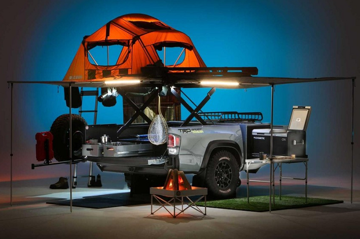 Như những gì được thấy ở đây, TRD Sport cho Toyota Tacoma có hệ thống thang cắt kéo có thể nâng bệ của nó lên cao trên 1 mét khỏi phần thùng. Nó tích hợp một lều trại Yakima cho 4 người với mái hiên và giá đỡ cần câu cá, một bộ tủ lạnh và tủ đông, một vòi tắm hoa sen di động hoàn chỉnh với rèm che và bình nước nóng.