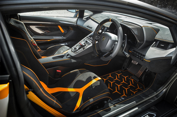 Bên trong cabin, nội thất được thiết kế chủ đạo theo màu Nero Cosmus Black Alcantara. Các điểm nhấn màu cam Arancio Leonis trên ghế, thảm và bảng táp-lô tạo sự tương phản.