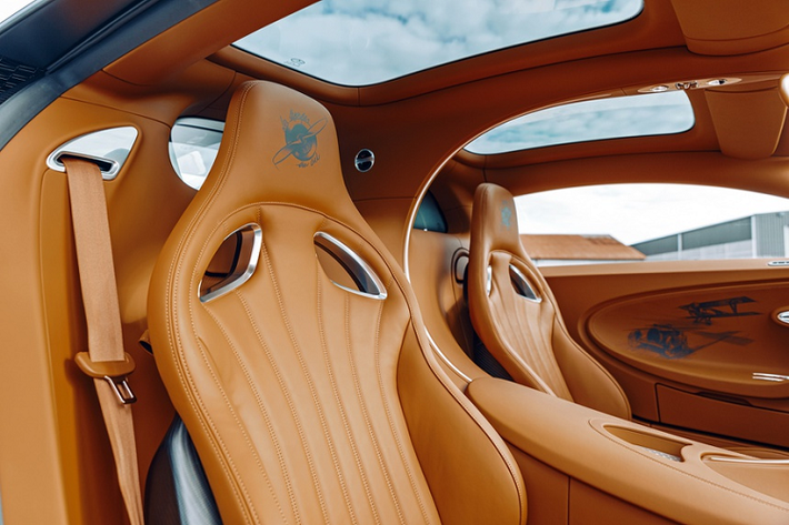 Nắp động cơ siêu xe Bugatti Chiron Sport Les Legendes du Ciel được phủ sợi carbon tối màu. Xe được trang bị động cơ W16 8.0L với 4 bộ tăng áp sản sinh công suất 1.500 mã lực và mô-men xoắn cực đại 1.600 Nm, cho phép siêu xe mới có thể chạy ở vận tốc tối đa theo giới hạn điện tử 420 km/h.