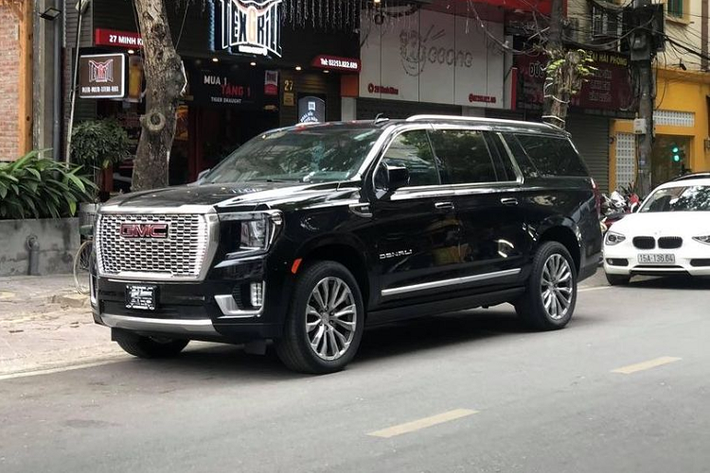 GMC Yukon XL Denali 2021 mới đầu tiên tại Việt Nam được đưa về thông qua một công ty nhập xe tư nhân. Bên cạnh ngoại hình to lớn, bệ vệ theo đúng chuẩn xe Mỹ, chiếc xe này còn có nước sơn ngoại thất màu đen, thuộc phiên bản XL với nhiều chi tiết trang trí ốp crome sáng bóng.