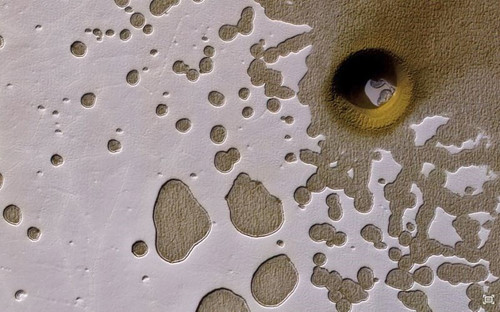 Tàu thăm dò sao Hỏa Mars (MRO) của NASA chụp ảnh hố lõm kỳ lạ trên sao Hỏa. Xung quanh miệng hố toàn băng và bụi. Khí Co2 lạnh phủ đầy miệng hố, phản ứng hóa học với các vật chất tạo ra một gam màu vàng pho mát độc lạ. Nguồn ảnh: Dailymail.