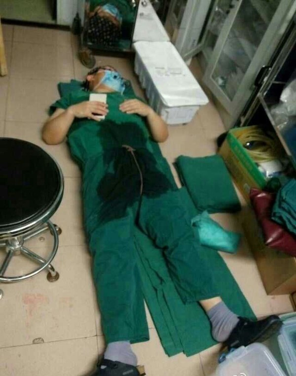 Người trong ảnh là BS.Trần Hưng Bành - BS. Khoa Tim - Bệnh viện Trung tâm Thành phố Lạc Dương, tỉnh Hà Nam (Trung Quốc). Trong ca trực mới nhất của bác sĩ, các ca phẫu thuật đã kéo dài liên tiếp đến 3h sáng mới kết thúc. Do quá sức khi phải mổ liên tục cho nhiều bệnh nhân nên sau khi ca mổ cuối cùng kết thúc, bác sĩ Hưng Bành đã nằm ngủ thiếp đi trong phòng phẫu thuật- Bức ảnh từng gây xúc động trong cộng đồng mạng Trung Quốc cũng như Việt Nam.