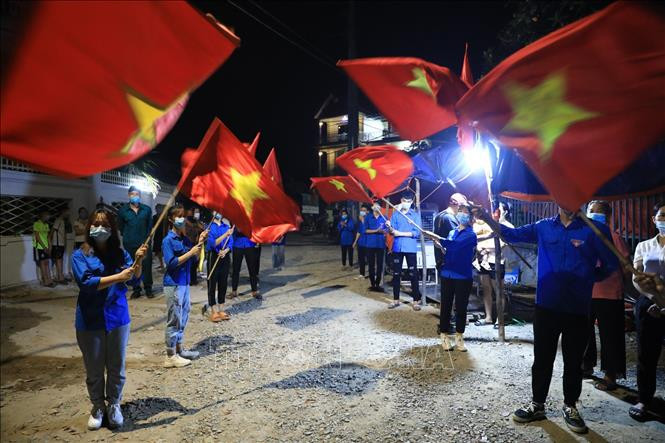 Lực lượng Đoàn Thanh niên thôn Lỗ Giao vui mừng phất cờ Tổ quốc sau khi có quyết định chính thức dỡ bỏ cách ly thôn.
