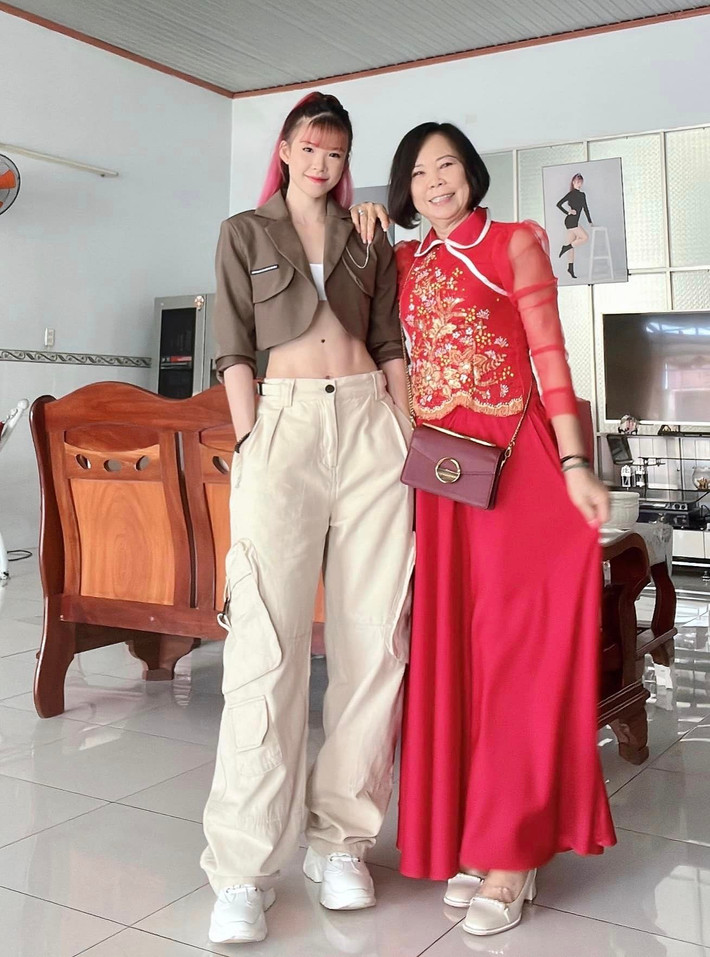 Dưới loạt ảnh chân dài miên man, giọng ca sinh năm 1990 tiết lộ do chính mẹ ruột làm "phó nháy": "Tui không có kéo chân mọi người ơi. Má Năm chụp cho tui chĩa cái điện thoại từ dưới lên làm tui thành 2 mét. Lỗi tại má Năm đó".