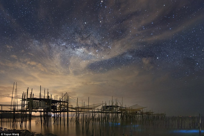Ánh sáng tự nhiên nhưng cực kỳ yếu ớt của thiên hà Milky Way khoe sắc trên bầu trời một làng chài Kelong, tại Batu Pahat, Malaysia. Nguồn ảnh: Dailymail.