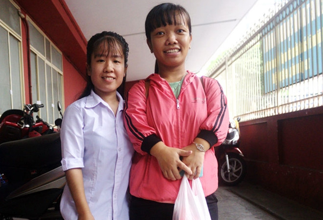 Lâm Thị Kim Bông và Trần Thị Kim Luyến lọt thỏm giữa hàng trăm thí sinh làm thủ tục dự thi THPT Quốc gia 2019 tại điểm thi THCS Colette (quận 3, TP.HCM). Hai nữ sinh nhỏ thó, bị teo cơ do di chứng bệnh sốt bại liệt hồi nhỏ. Với ước mơ làm cô giáo, Kim Bông và Kim Luyến quyết tâm thi vào ngành Giáo dục đặc biệt của Đại học Sư phạm TP HCM. Ảnh: Như Quỳnh.