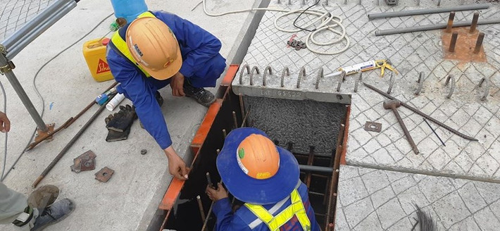 Công nhân tiến hành bắt ốc, đai bulông giữa phiến dầm nặng khoảng 70 tấn với hệ thống xà mũ của bệ trụ cầu cạn chạy trên đường Phạm Văn Đồng. (Ảnh: Việt Hùng/Vietnam+)