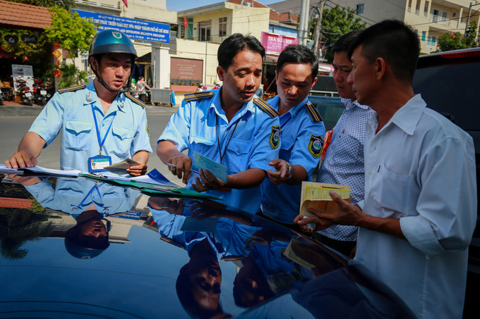 Đội quản lý trật tự đô thị quận 3 lập biên bản xử phạt một chủ ôtô đậu lấn chiếm vỉa hè trên đường Lý Chính Thắng.