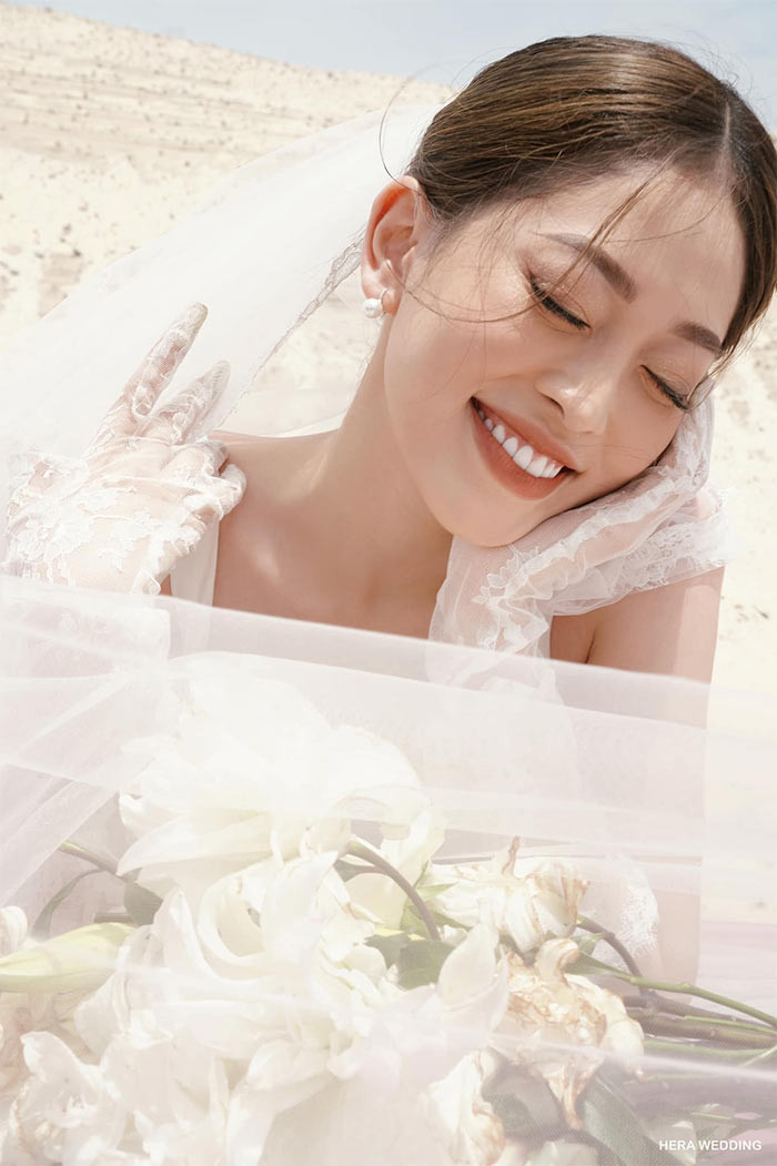 Trong bộ ảnh cưới Phương Nga - Bình An, cô dâu xinh tươi trong bộ váy trắng, tạo dáng trên cồn cát.