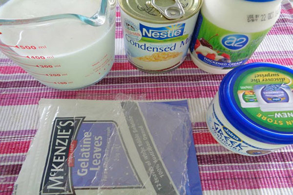 Đầu tiên, hãy chuẩn bị đầy đủ nguyên liệu: sữa tươi, sữa chua cái, sữa bột mi lô, rau câu, hộp đựng sữa chua, lá glatin, nước sôi. Ảnh: Congthucmonngon.