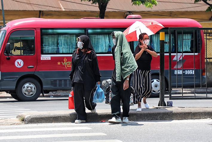 Người che ô, người trùm áo lên đầu và chạy thật nhanh sang đường tìm nơi bóng mát.