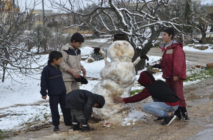 Các cậu bé đang đắp người tuyết ở vùng quê Jabal al-Zawiya thuộc thành phố Idlib, Syria ngày 7/1/2015.
