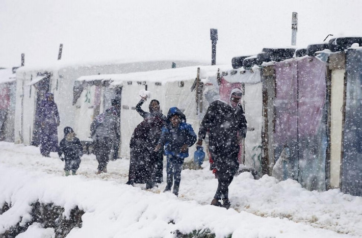 Người tị nạn Syria đi bộ bên ngoài lều khi tuyết rơi ở 1 khu trại tị nạn ở quận Zahle trong thung lũng Bekaa, Lebanon ngày 7/1/2015.