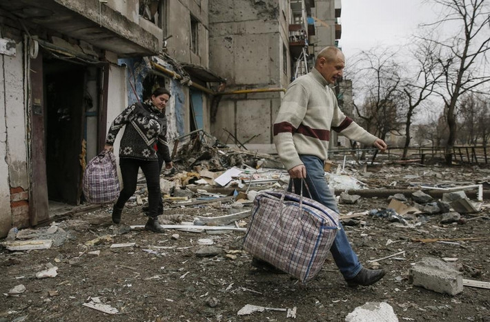Người dân rời khỏi khu nhà tan hoang ở thành phố Yenakiieve, phía đông bắc Donetsk ngày 2/2/2015.