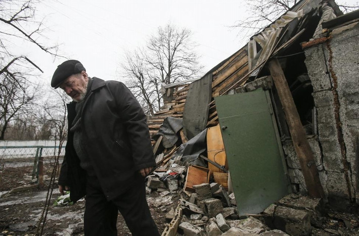 Người đàn ông đi qua 1 ngôi nhà bị phá hủy ở thành phố Yenakieve, phía đông bắc Donetsk ngày 2/2/2015.