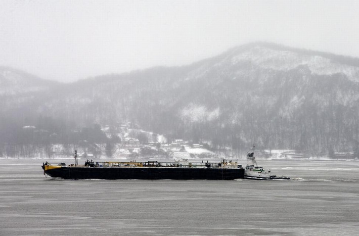 Một chiếc sà lan di chuyển trên sông Hudson khi tuyết bao phủ núi Hook và ngôi làng Upper Nyack,New York ngày 2/2/2015.