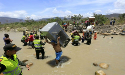 Hàng trăm người dân Colombia mang theo đủ thứ đồ như tủ lạnh, chiếu, quạt điện, gà vịt, dê,...vượt sông.