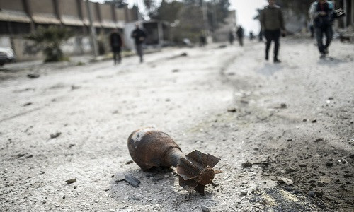 Một quả đạn pháo không phát nổ nằm trên đường đường phố Kobani.