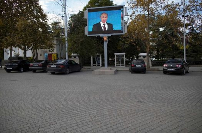 Màn hình lớn chiếu hình ảnh Tổng thống Nga Vladimir Putin khi ông nói chuyện với các chuyên gia chính trị tại 1 cuộc họp của Câu lạc bộ quốc tế Valdai tại quảng trường Nakhimov ở thành phố Sevastopol, Crimea ngày 26/10/2014. Theo đó, Tổng thống Nga Vladimir Putin đã hứa Crimea "sẽ là ngôi nhà cho tất cả các dân tộc sinh sống ở đó".