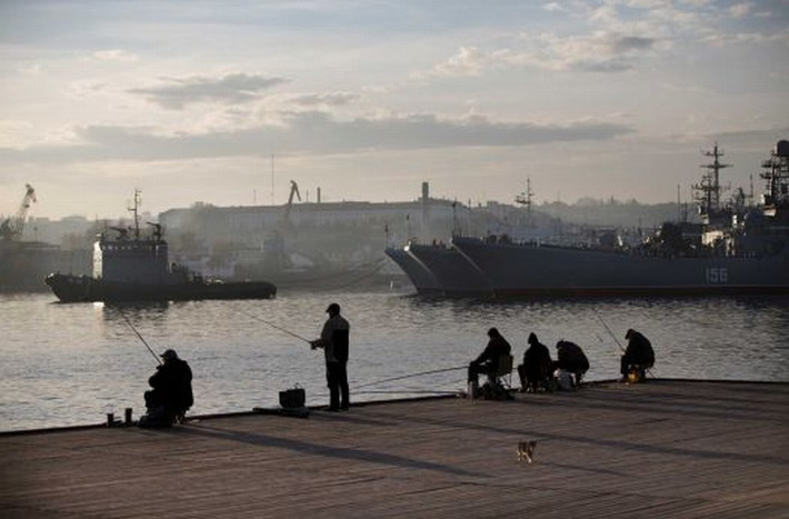 Ngư dân địa phương câu cá ở phía trước tàu Hải quân Nga ở thành phố Sevastopol , Crimea ngày 27/10/2014.