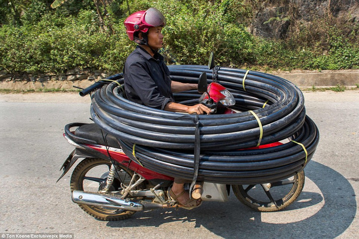 Những đường ống dẫn nước bằng nhựa gần như chiếm trọn chiếc xe máy của người đàn ông này.