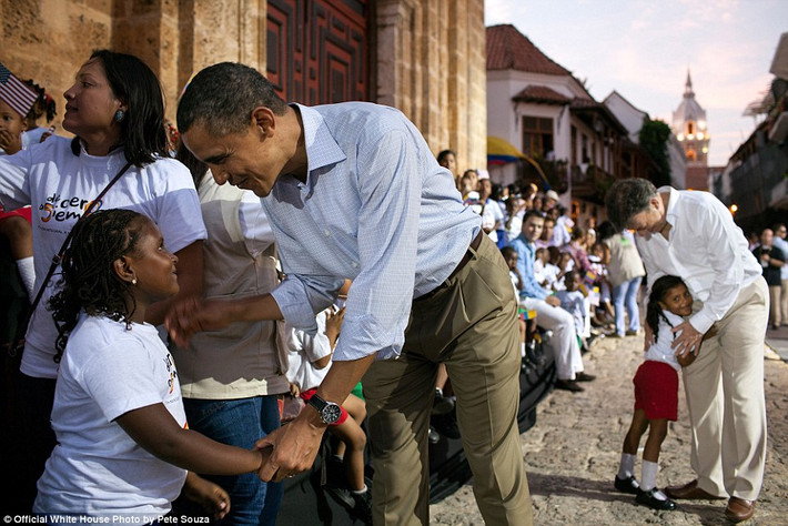 Obama mỉm cười bắt tay một bé gái ở quảng trường San Pedro, Colombia ngày 15/4/2012.