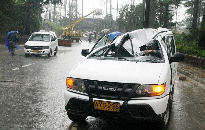 Chiếc ôtô bẹp rúm sau khi cơn bão làm đổ một cột điện ở thành phố Baguio, miền bắc Philippines ngày 21/8.