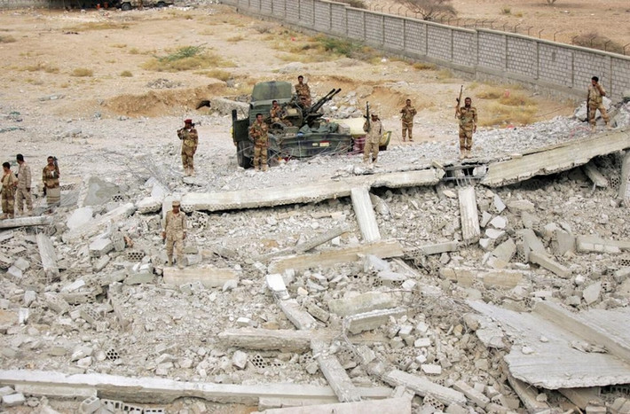Binh lính Yemen đứng trên xác 1 chiếc xe tăng ở 1 doanh trại cảnh sát, nơi bị đánh bom bởi lực lượng al Qaeda ở al-Mahfad thuộc tỉnh Abyan, phía nam Yemen ngày 23/5/2014.