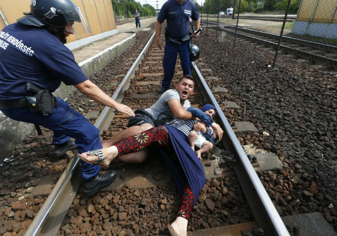 Một gia đình nhập cư ngã xuống đường ray tàu ở thị trấn Bicske, Hungary ngày 3/9/2015.