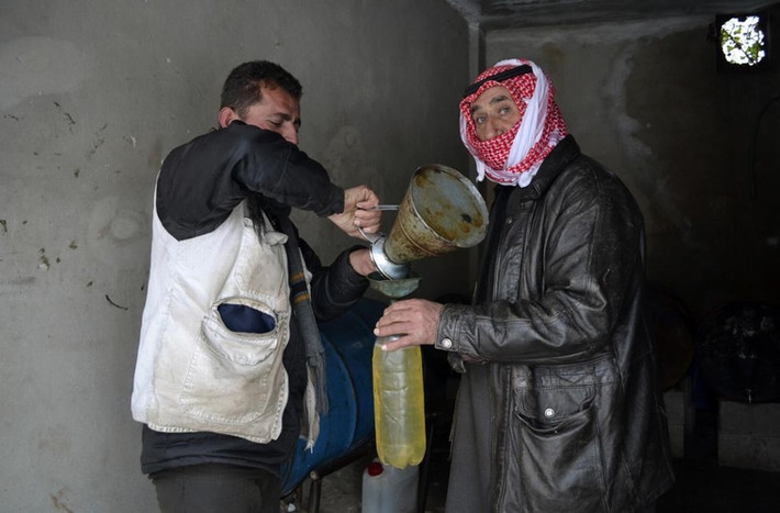 1 người đàn ông mua nhiên liệu để sưởi ấm ở thành phố Idlib, Syria ngày 10/1/2015.