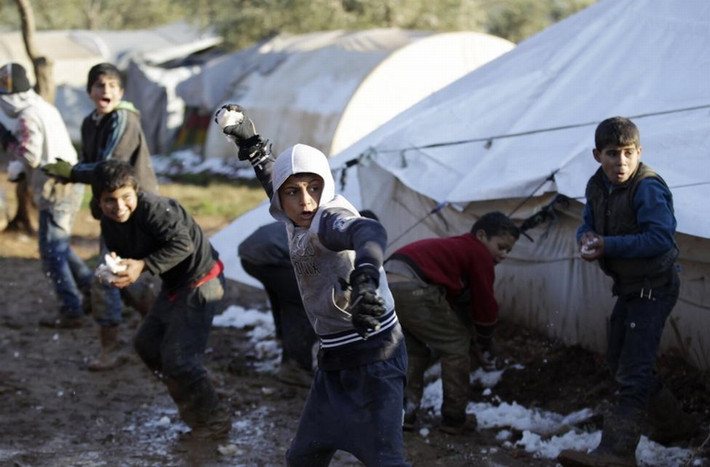 Những đứa trẻ chơi đùa với tuyết tại khu vực trại tị nạn Atma giáp biên giới Syria-Thổ Nhĩ Kỳ phía bắc thành phố Idlib, Syria ngày 11/1/2015.