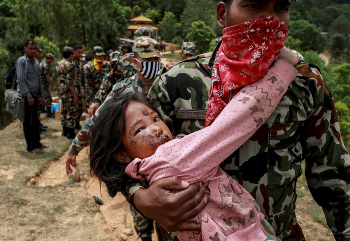 Vụ động đất Nepal đã khiến cho hơn 21.000 thương vong và gây thiệt hại hàng tỷ USD. Trong hình là một bé gái bị thương được đưa ra máy bay trực thăng ở Sindhupalchowk.
