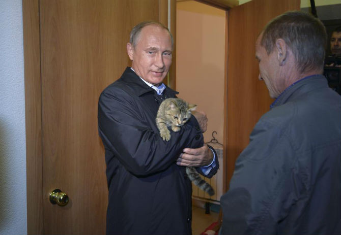 Ông Putin bế một chú mèo khi đang thị sát một công trình xây dựng nhà ở dành cho người dân chịu ảnh hưởng của vụ cháy rừng ở làng Krasnopolye, Nga, ngày 4/9/2015.