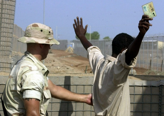 NATO tham dự vào các hoạt động ở bờ biển thuộc Bán đảo Somalia từ năm 2008. Trong hình, 1 quan chức NATO đang lục soát 1 công nhân ở Jibuti.