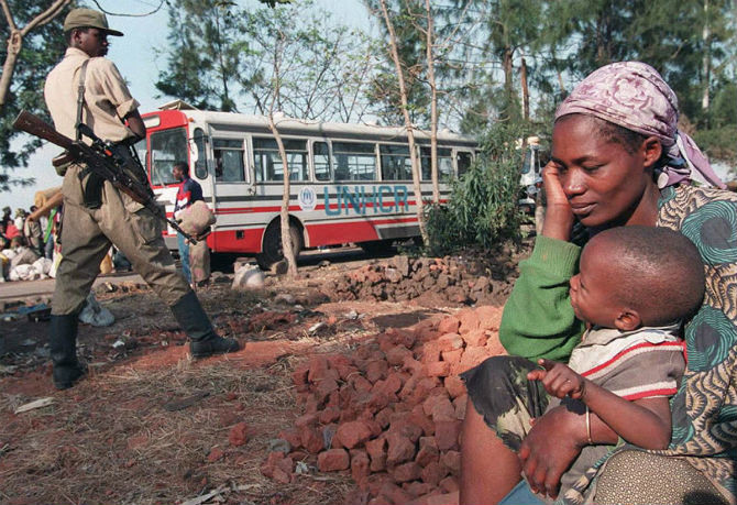 Một bà mẹ ngồi ôm con nhỏ vào lòng ở khu vực giữa Zaire và Rwanda để chờ lên xe buýt trở về Rwanda ngày 22/8/1995.