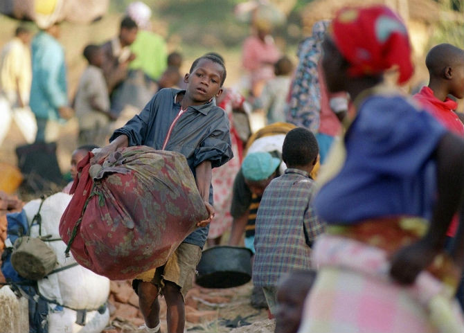Một bé trai người Rwanda khiêng bao tải lớn cùng mọi người chạy trốn khỏi trại tị nạn ở Đông Zaire ngày 22/8/1995.