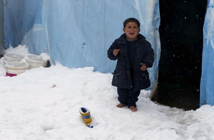 1 cậu bé tị nạn người Syria khóc thét vì lạnh khi đứng chân trần trên tuyết bên ngoài 1 túp lều ở khu vực trại tị nạn ở quận Zahle trong thung lũng Bekaa, nước cộng hòa Lebanon ngày 7/1/2015.