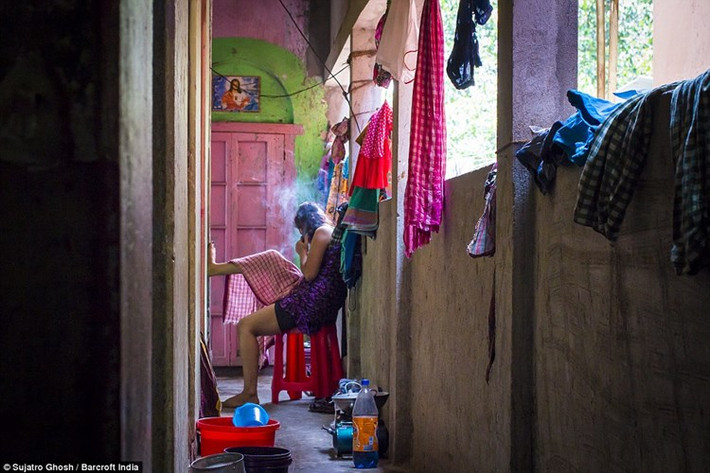Một gái bán dâm đang hút thuốc bên ngoài hành lang khu nhà thổ. (ảnh: Barcroft India/DM).