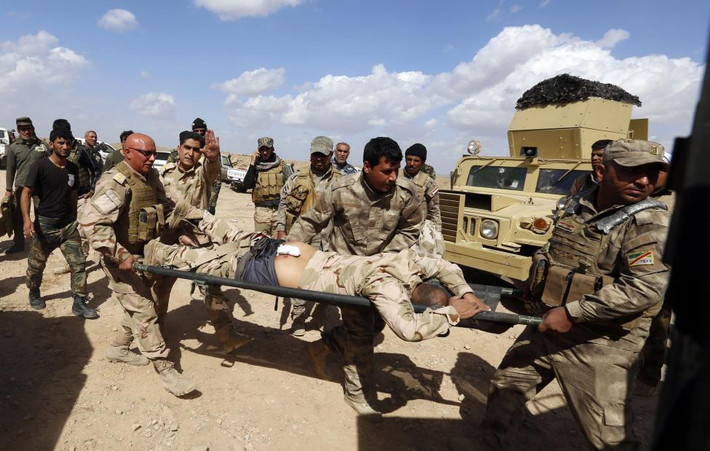 Một binh sĩ Iraq bị thương trong cuộc đụng độ với nhóm Hồi giáo cực đoan IS đang được đưa ra khỏi khu vực chiến sự.
